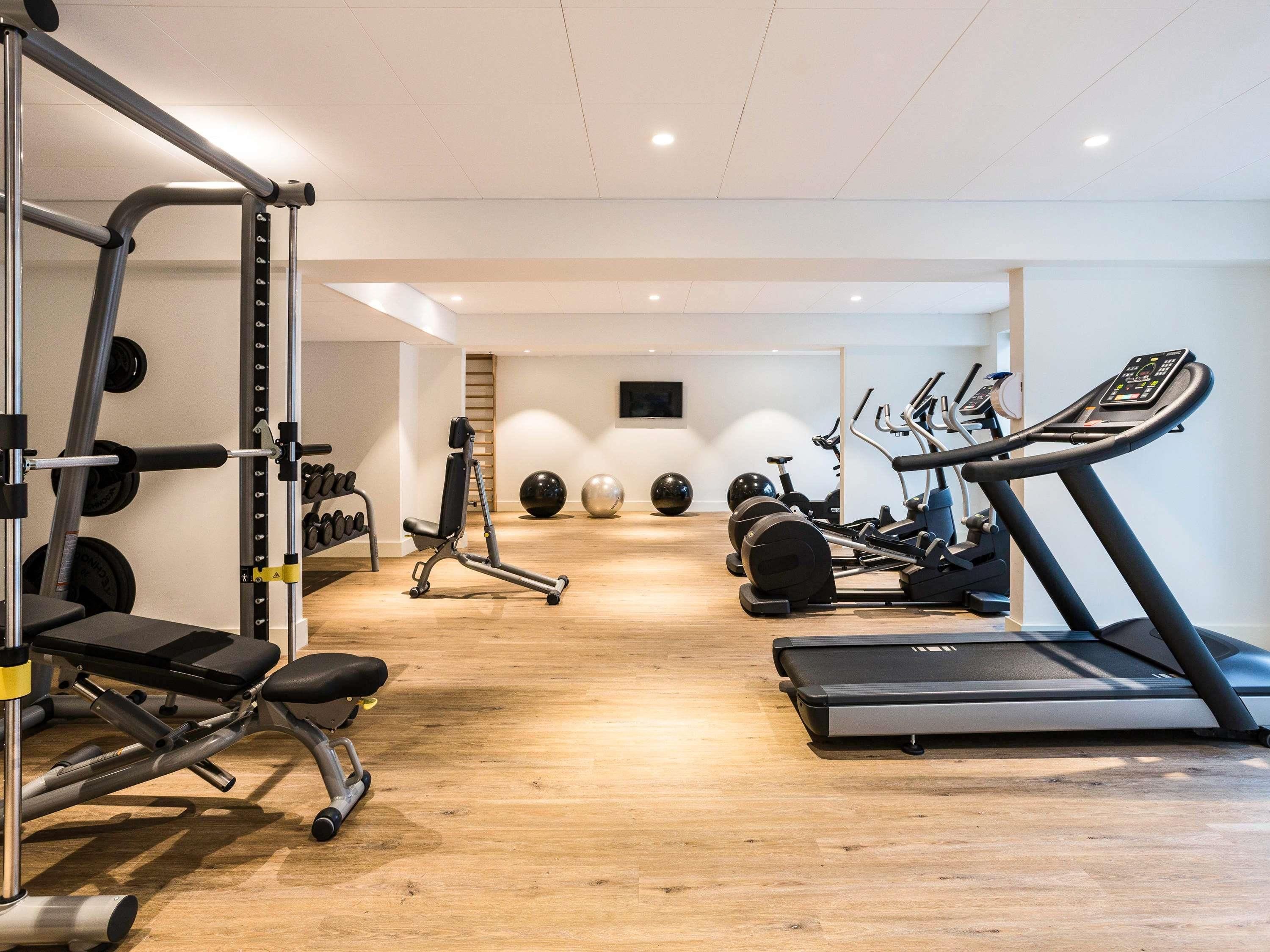 A gym with cardio equipment, weight machines, and exercise balls.