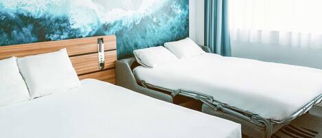 A hotel room with two beds, a wooden headboard, a large abstract mural, and a view of the sea.