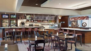 A modern hotel lobby with a bar area, seating arrangements, and a menu display. - Courtyard by Marriott Tallahassee Downtown/Capitol (Tallahassee)