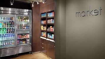 Un espace équipé de distributeurs automatiques proposant diverses boissons et collations, ainsi qu’un mur sur lequel est inscrit le mot « market ».