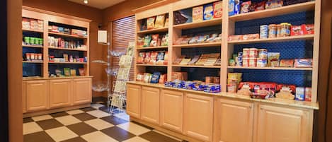 A well-lit store with shelves stocked with various food items and a checkered floor.