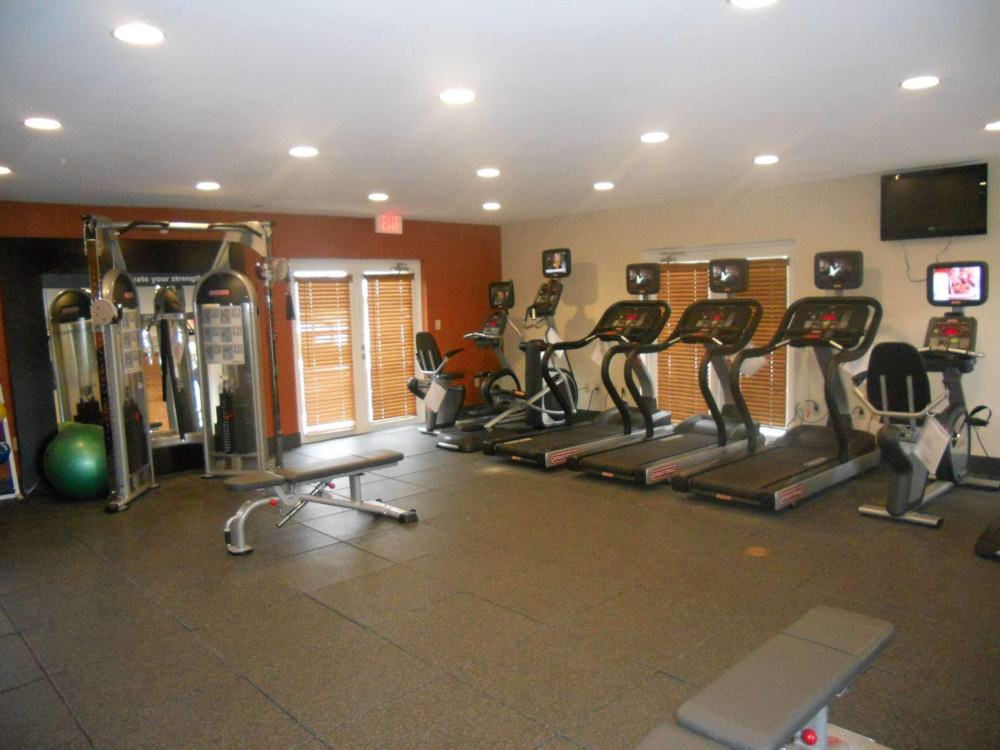 A gym with treadmills, elliptical machines, and weightlifting equipment.