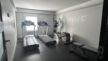 A gym with treadmills, an elliptical, and a stationary bike.