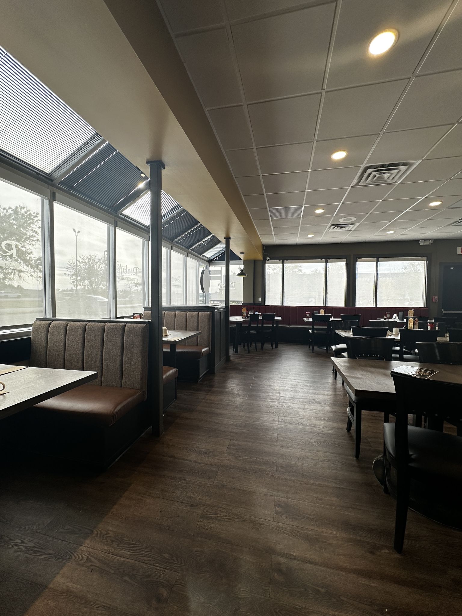 A restaurant interior with booths, tables, and large windows.
