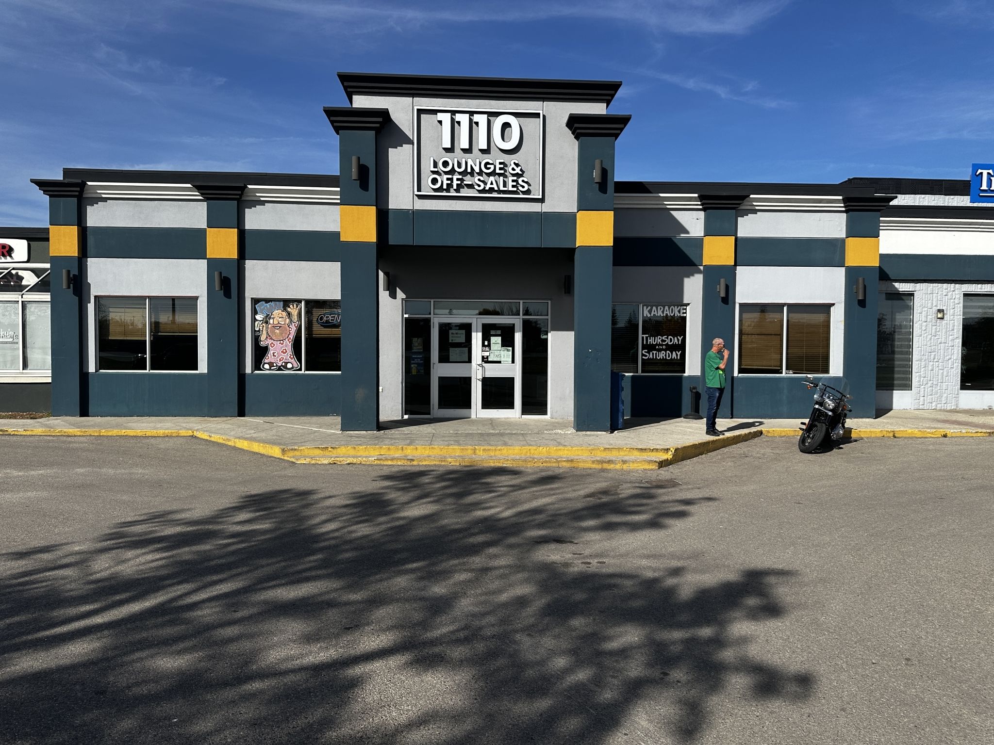 A building with a sign reading '1110 Lounge & Off-Sales' and a 'Karaoke' sign indicating entertainment options.