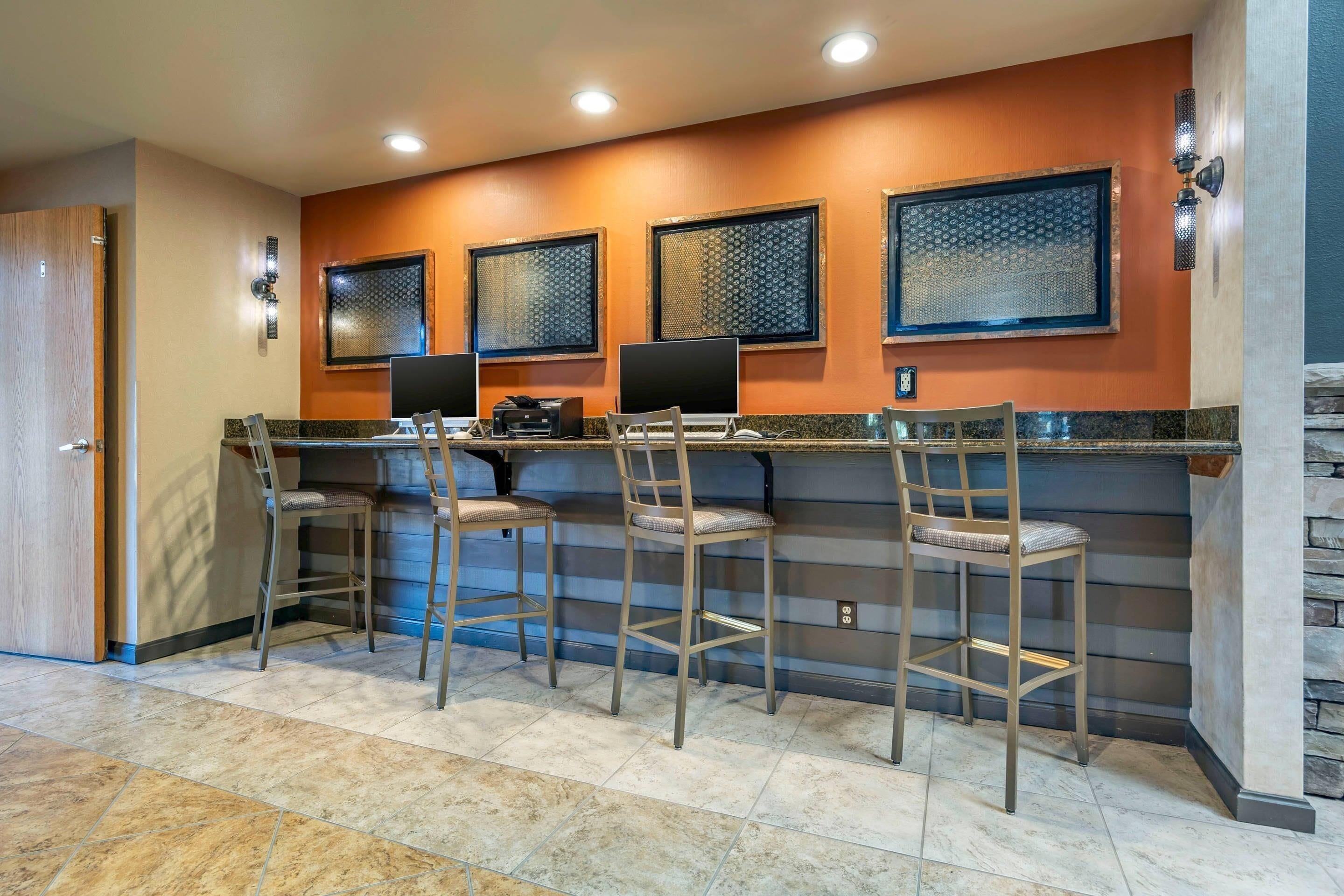 A bar area with four stools, a counter, and three patterned windows.