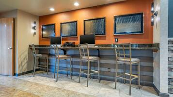 A bar area with four stools, a counter, and three patterned windows.