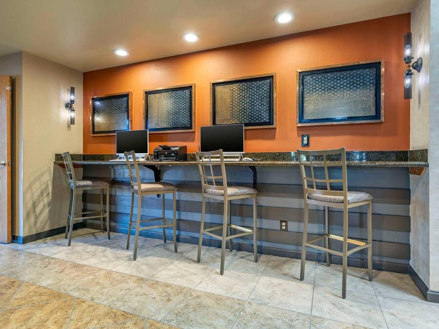 A bar area with four stools, a counter, and three patterned windows.