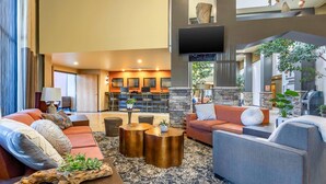 A spacious living area with a sofa set, a coffee table, and a fireplace. - Hells Canyon Grand Hotel, an Ascend Collection Hotel (Lewiston)