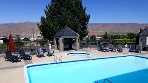 Una piscina techada, una piscina al aire libre, sombrillas