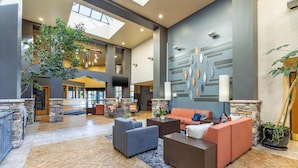A spacious lobby with a high ceiling, stone accents, and a large indoor tree. - Hells Canyon Grand Hotel, an Ascend Collection Hotel (Lewiston)