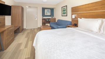 Une chambre d’hôtel équipée d’un lit, d’un bureau, d’une télévision, d’un four à micro-ondes et d’un coin salon.