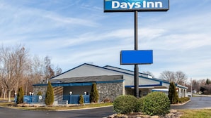 A Days Inn with a stone facade, a blue roof, and a clear sky. - Days Inn by Wyndham Kent - Akron (Kent)