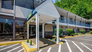 Ein Motel mit überdachter Eingangspartie, Parkplatz und einem Gebäude, an dem das Schild 'LARRY'S' zu sehen ist.