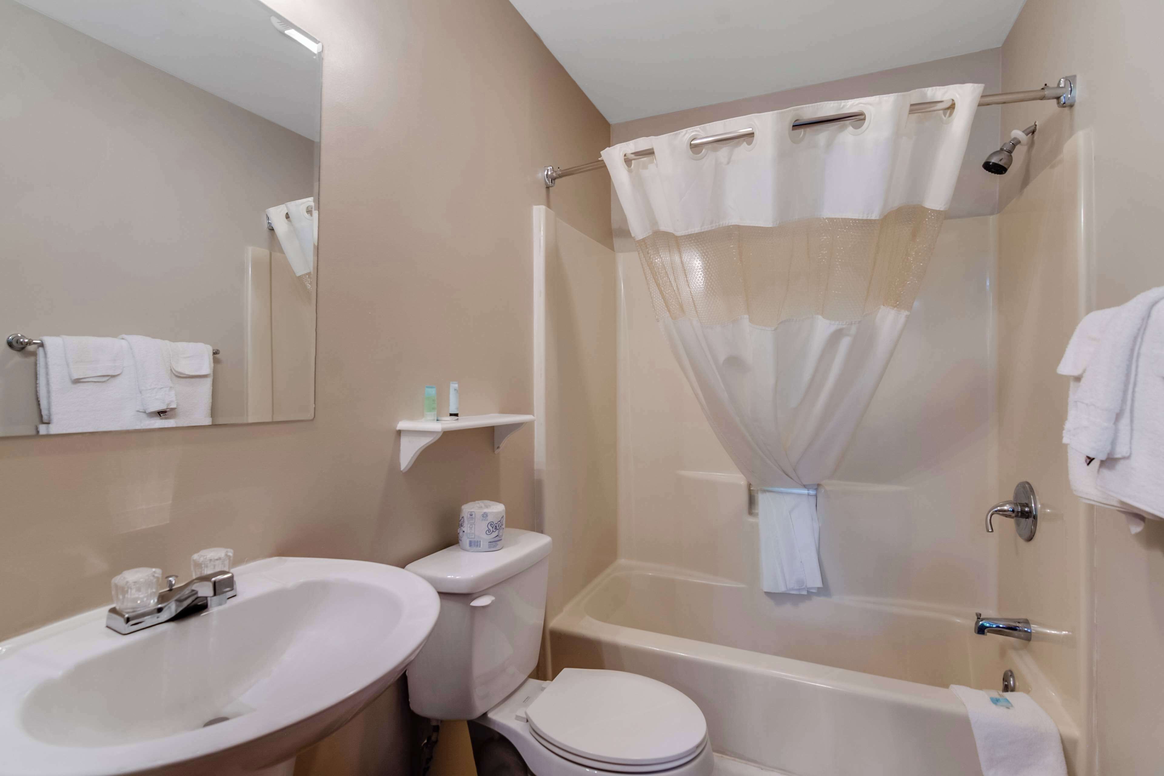A bathroom with a sink, toilet, and bathtub.