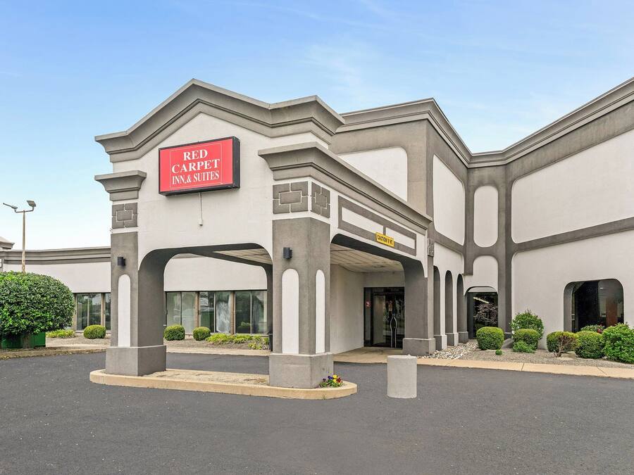 A Red Carpet Inn & Suites with a modern architectural design, featuring a prominent entrance and a well-maintained exterior.