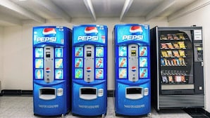 Three blue Pepsi vending machines with a snack vending machine to the right.