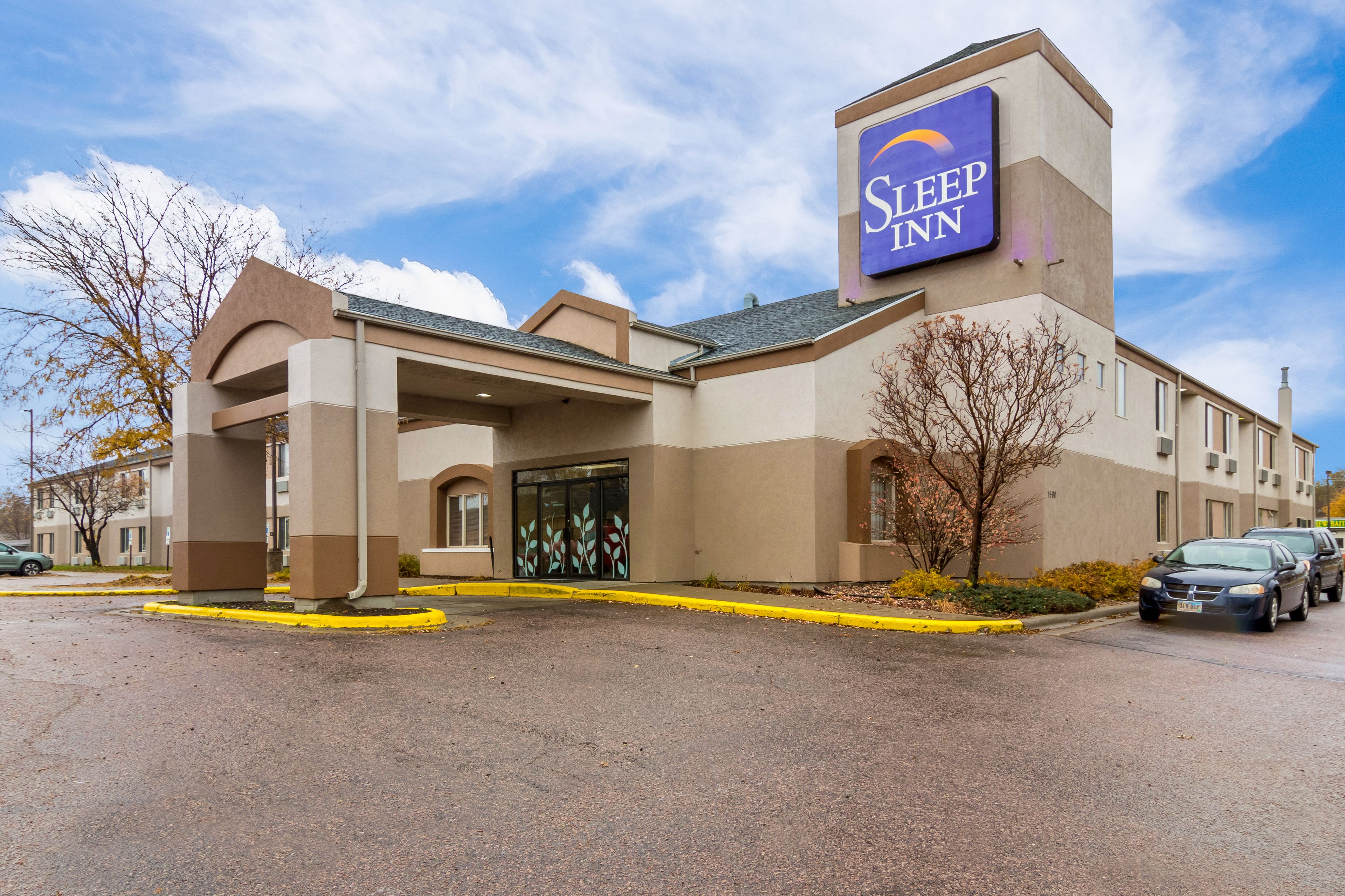 A Sleep Inn hotel with a prominent sign, a covered entrance, and a parking lot.