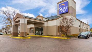 A Sleep Inn hotel with a prominent sign, a covered entrance, and a parking lot.