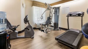Un gimnasio con cintas de correr, elípticas y máquinas de pesas.
