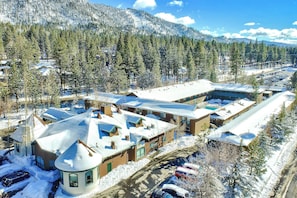 A snow-covered residential area with multiple houses, a parking lot, and a mountainous backdrop. - Forest Suites Resort at Heavenly Village (South Lake Tahoe)
