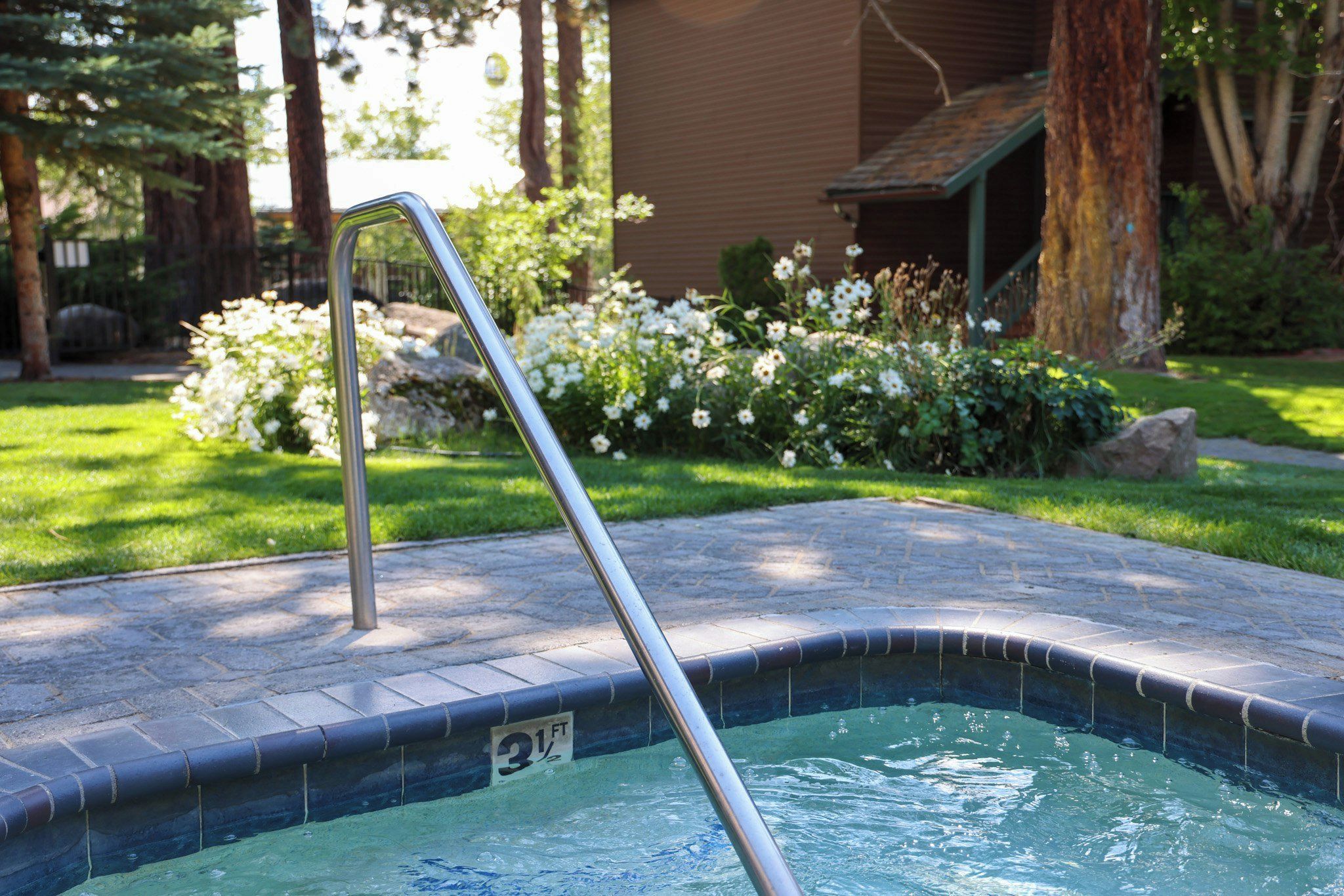 Una piscina con una escalera metálica y un indicador de profundidad que marca 31 pies.