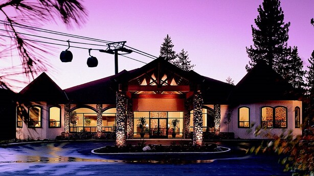 A large hotel with a central entrance, multiple wings, and a well-maintained lawn.
