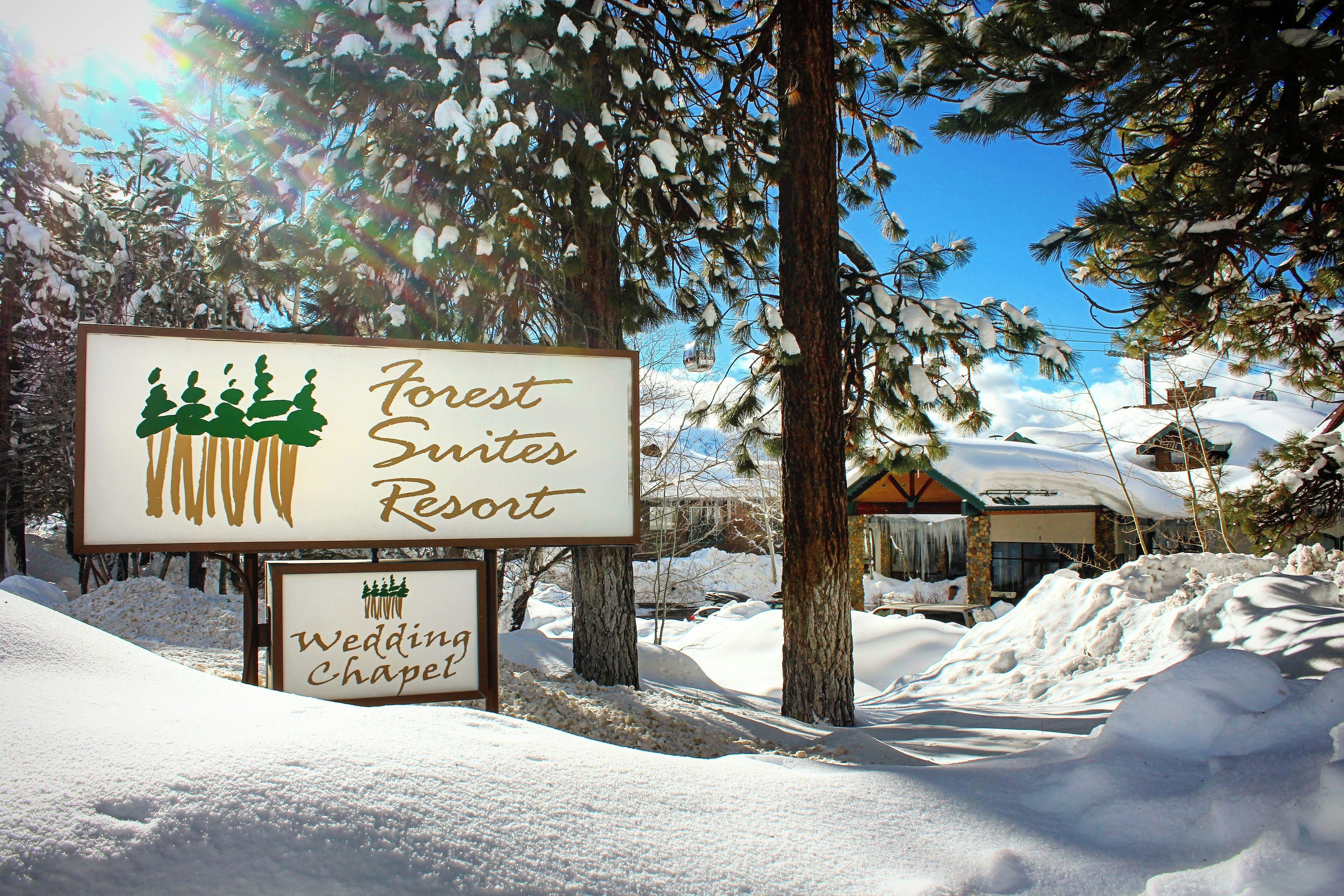 A sign for Forest Suites Resort with a wedding chapel.