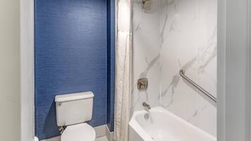 Une salle de bain équipée de toilettes, d’une baignoire et d’un rideau de douche.