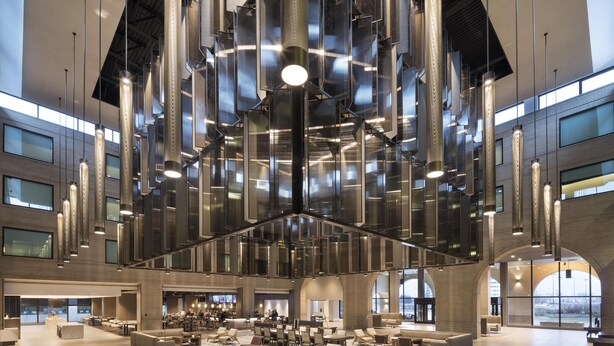 A spacious lobby with a modern design, featuring a central seating area with sofas and chairs, a large open space, and a high ceiling with hanging light fixtures. - Hyatt Regency Schaumburg Chicago (Schaumburg)