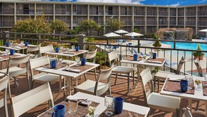 Een dakterras met terras, een zwembad en uitzicht op een hotelgebouw.