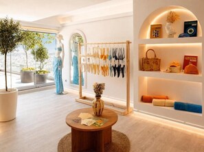 A modern interior with a mannequin, a clothing rack, and a shelf with items. - St. George Lycabettus Lifestyle Hotel (Athens)