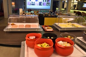 A buffet with various food items and condiments.