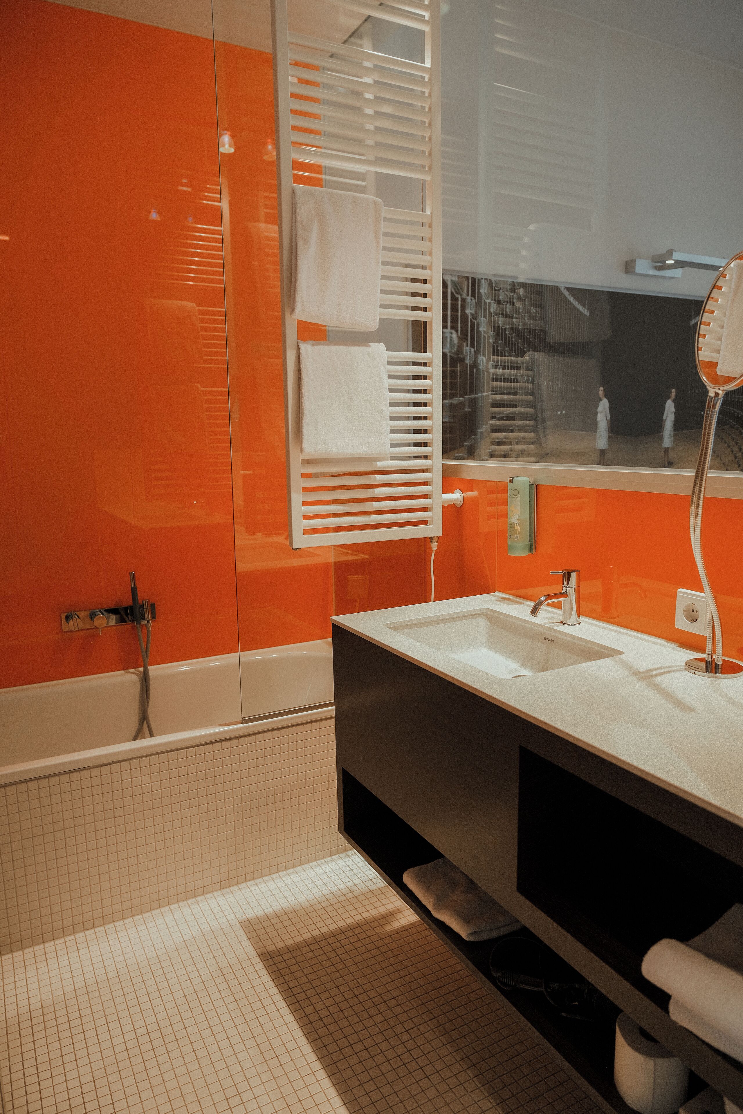Un baño con un lavamanos blanco, un espejo y una ducha.