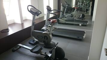 A gym with various exercise equipment including treadmills and stationary bikes.
