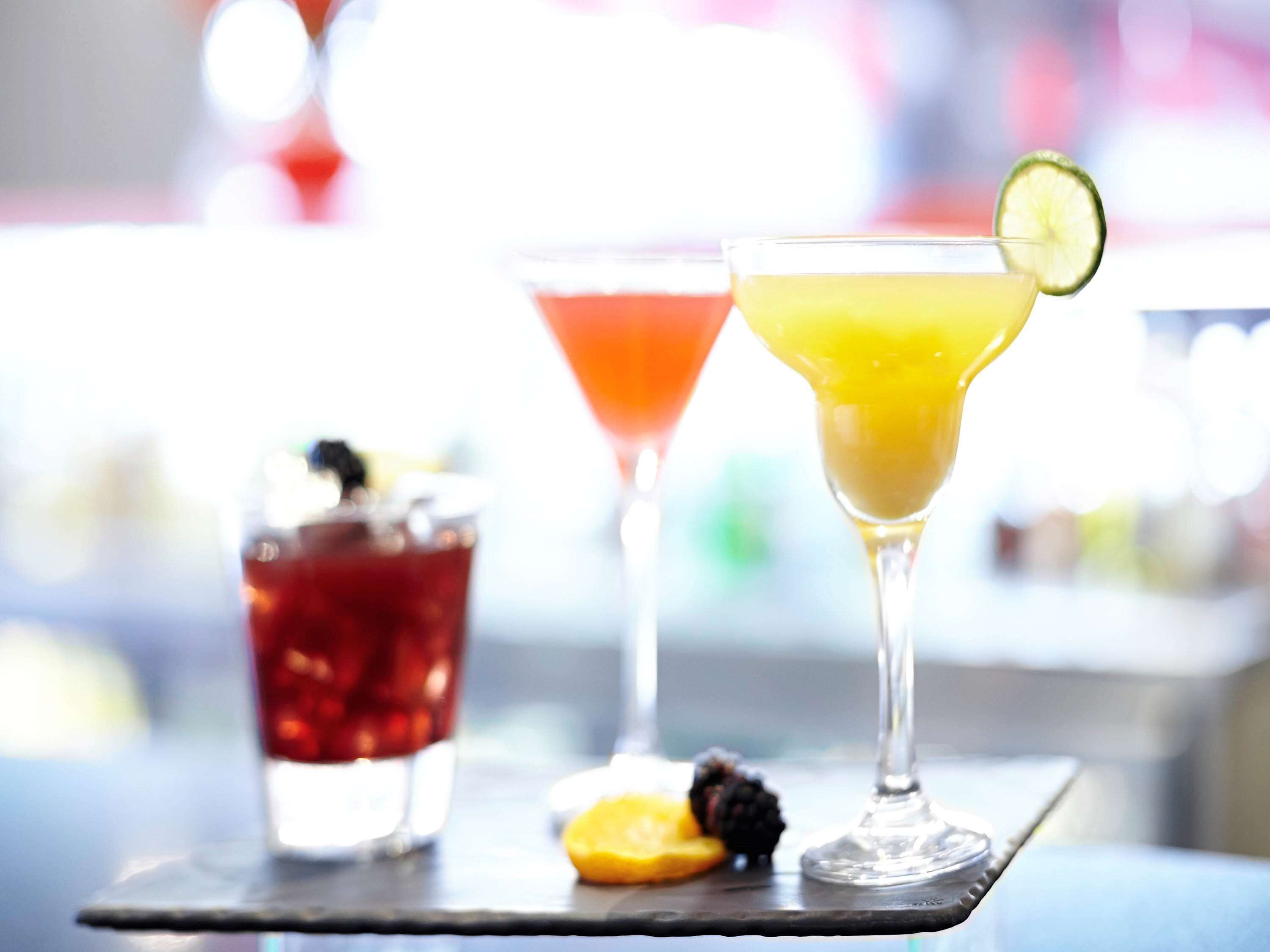 Zwei Cocktails auf einer Bar, unscharfer Hintergrund.