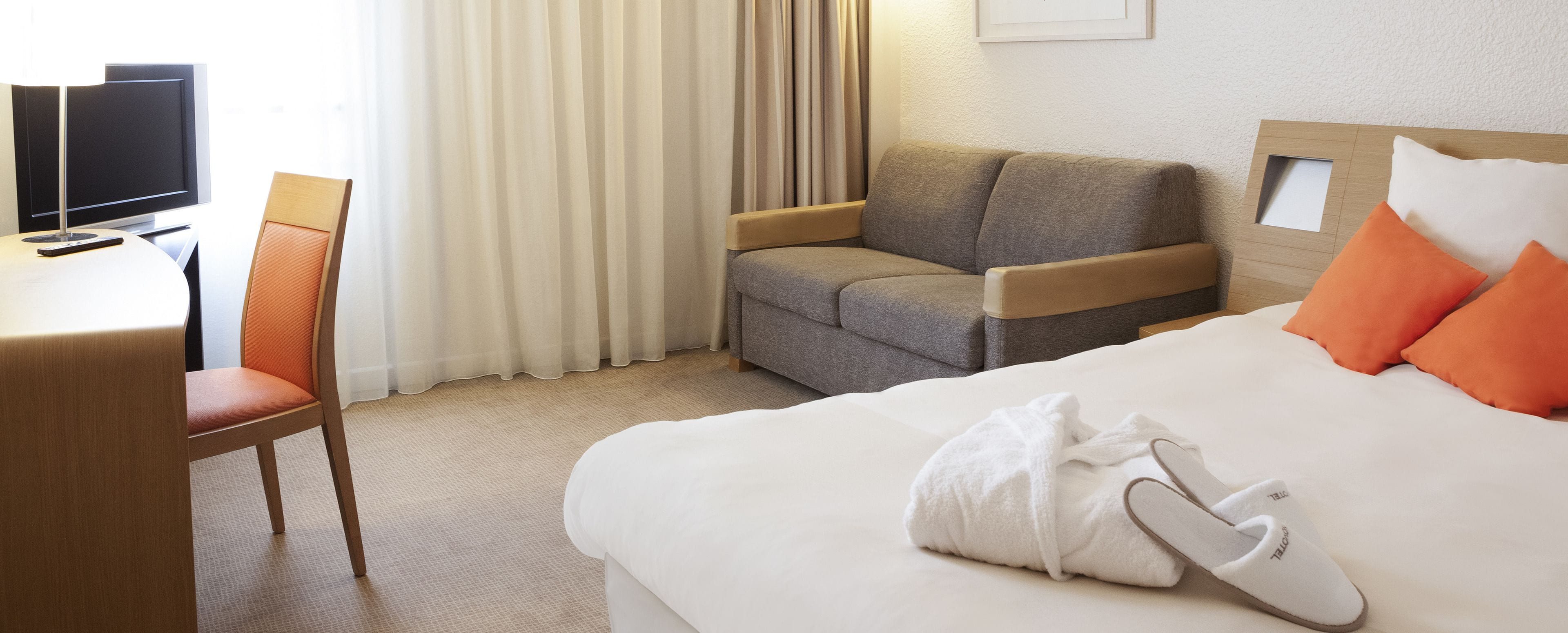 Une chambre d’hôtel équipée d’un lit, d’un bureau, d’une chaise et d’un téléviseur.