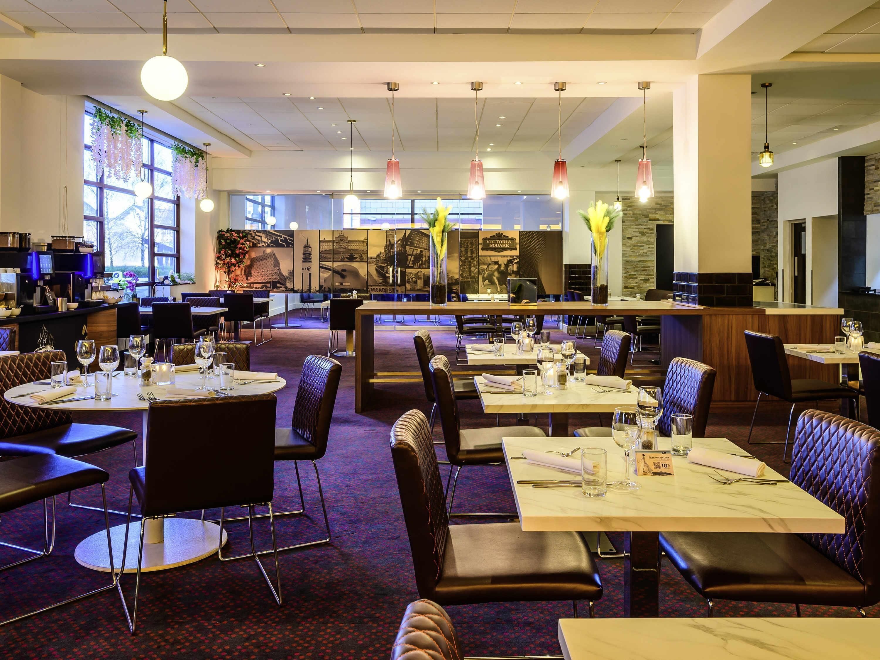 A restaurant with multiple dining tables and booths, a bar area, and a large window with a view.