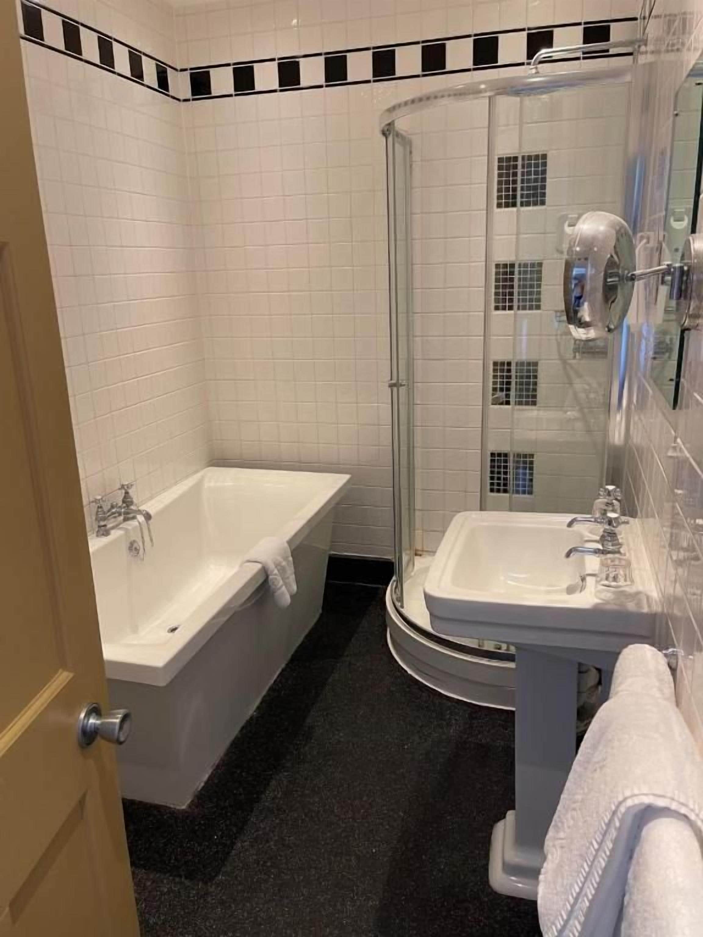 A bathroom with a bathtub, a shower, and a sink.