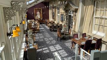 A hotel lobby with a patterned floor, multiple seating areas, and a large window.