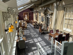 A hotel lobby with a patterned floor, multiple seating areas, and a large window. - The Manor Hotel by Greene King Inns (Yeovil)