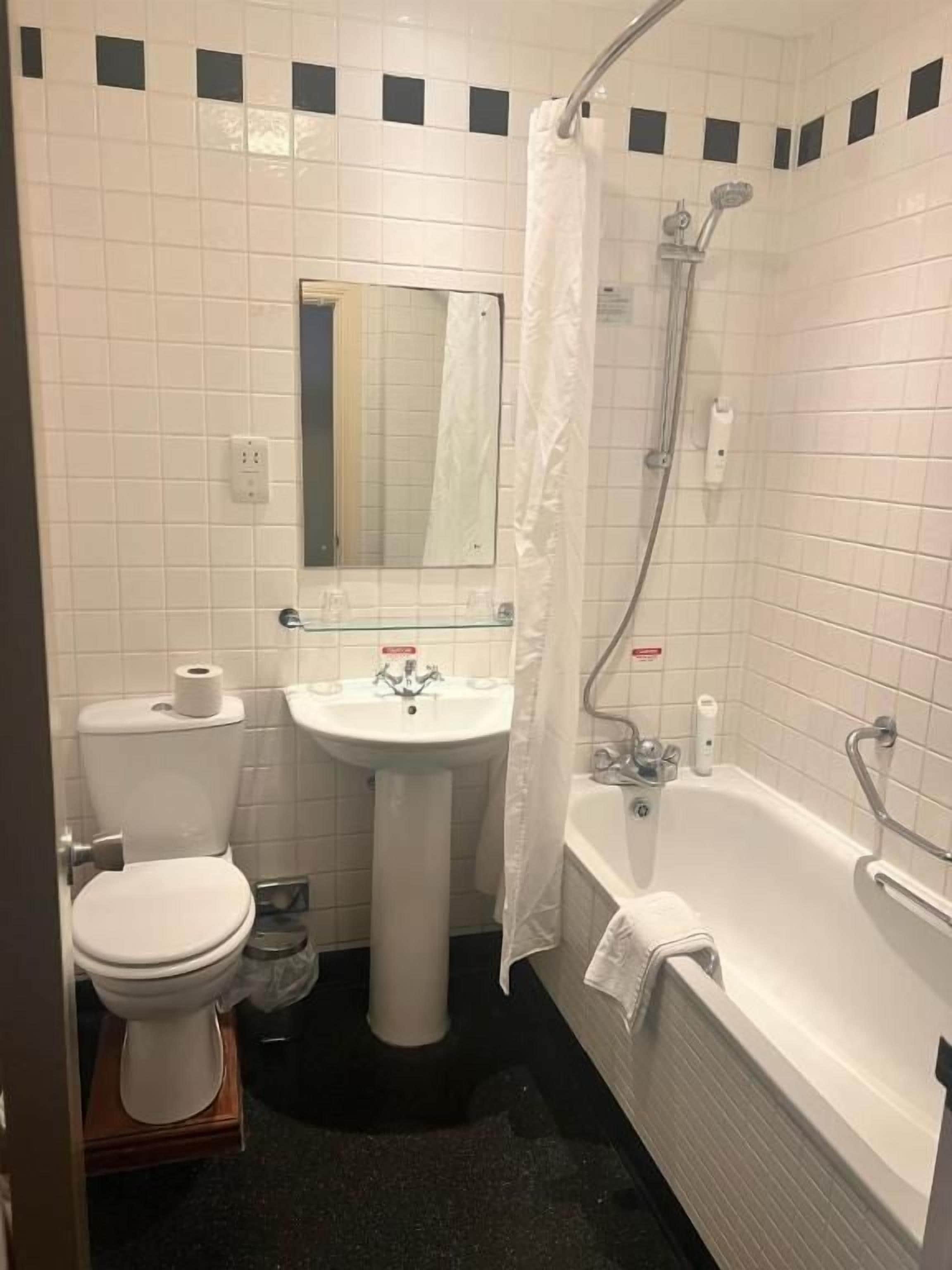 Ein Badezimmer mit Toilette, Waschbecken und Badewanne.