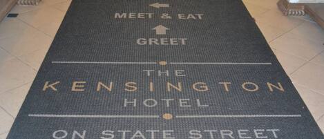 Tapete de entrada de hotel con flechas direccionales y el nombre del hotel.