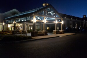 A modern hotel with a glass facade, a prominent sign, and a well-lit entrance area. - The Kensington Hotel (Ann Arbor)
