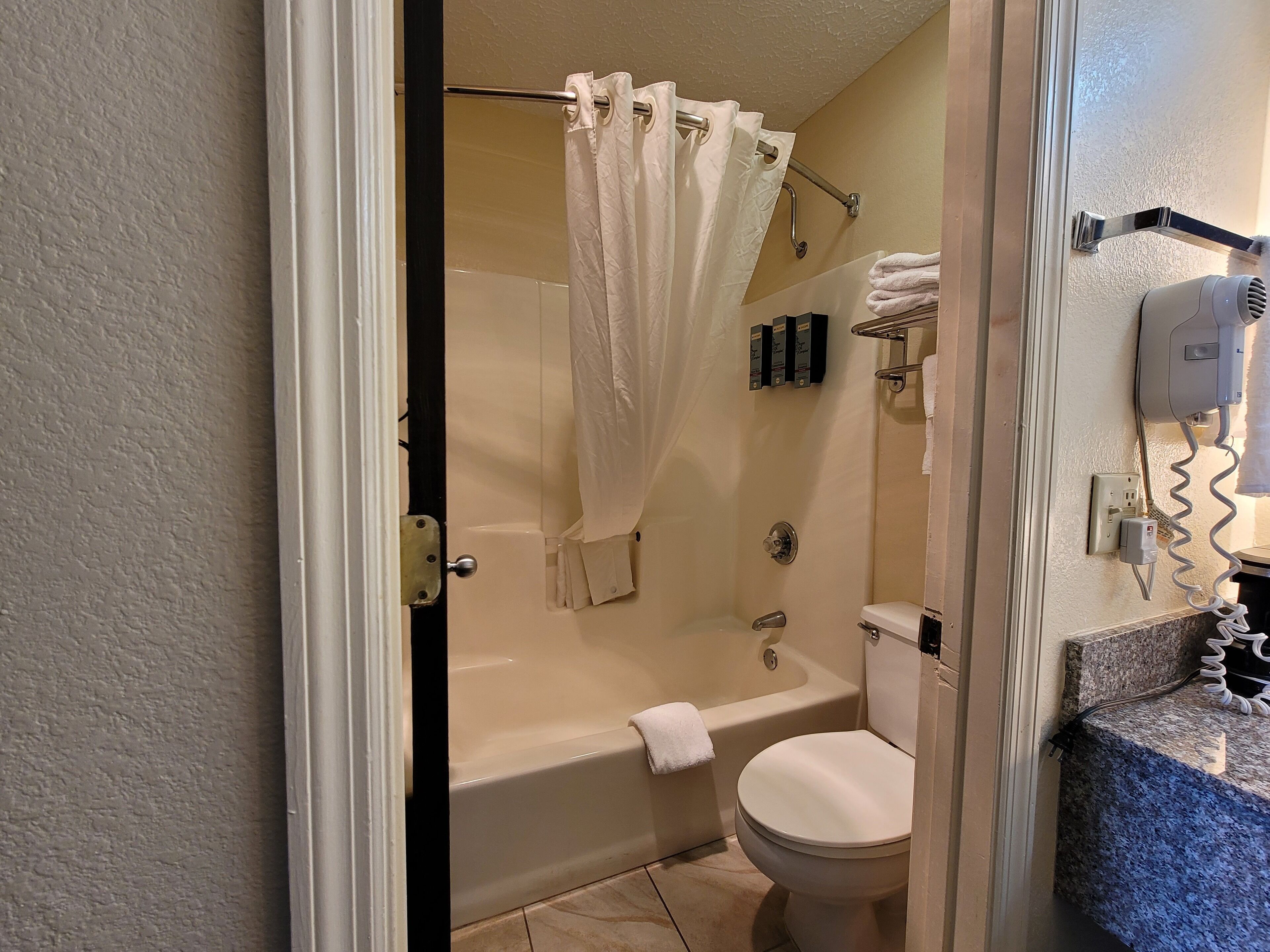 A bathroom with a bathtub, toilet, and a shower curtain.