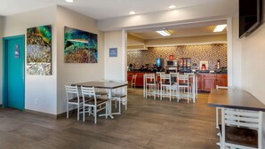 Una cocina moderna con piso en patrón de espiga, armarios blancos y una isla roja.