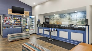 A reception area with a counter, seating, and a wall-mounted TV. - Best Western Westgate Inn (York)