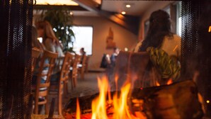 A cozy indoor setting with a fireplace, wooden chairs, and a dining area. - Best Western Plus Tree House (Mount Shasta)