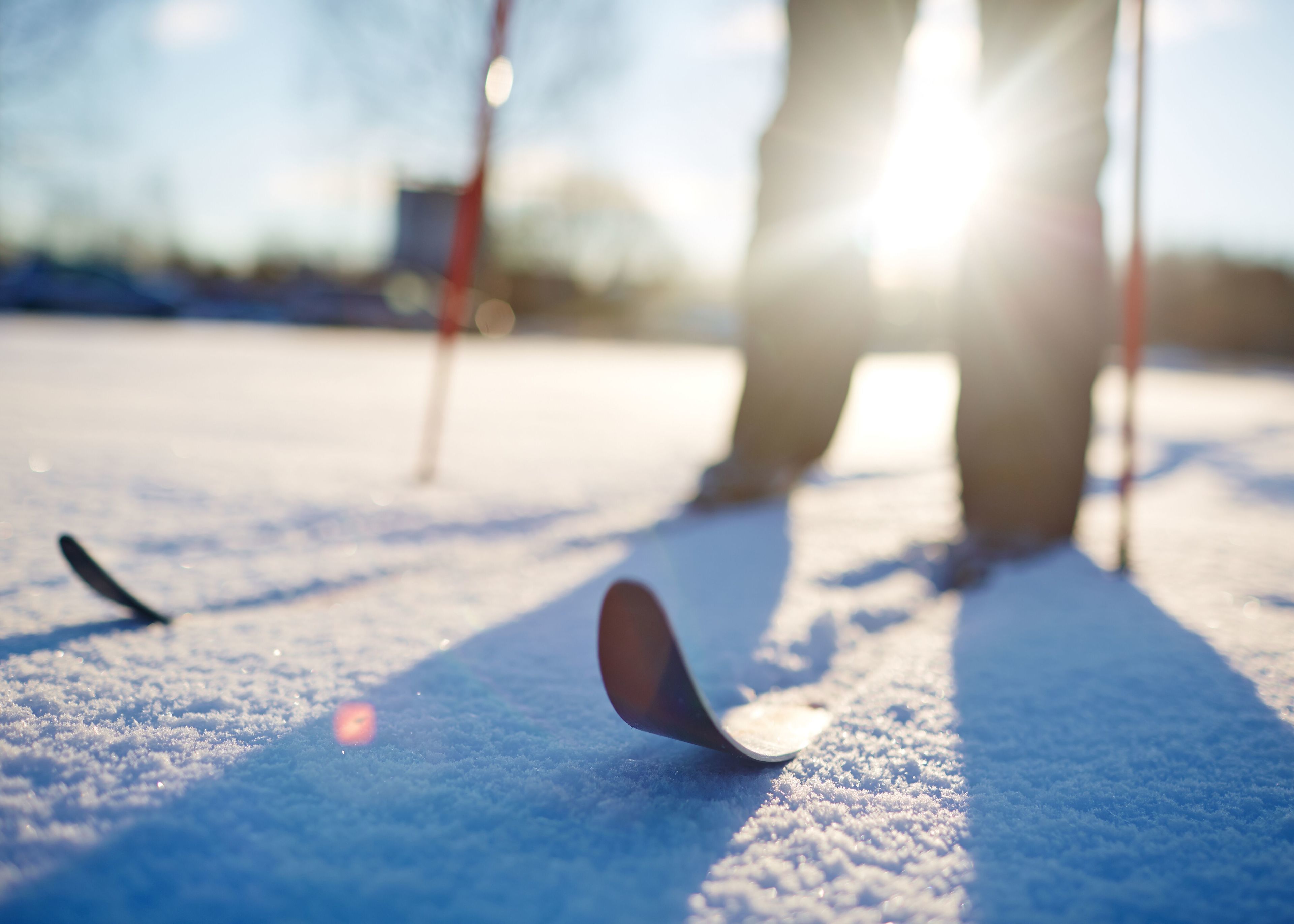 A person playing curling on a snowy surface with a curling stone and broom.