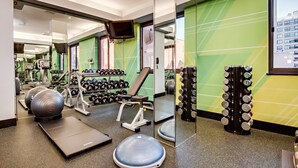 A gym with exercise equipment, a mirror, and a green wall. - Holiday Inn Washington-Central/White House by IHG (Washington)